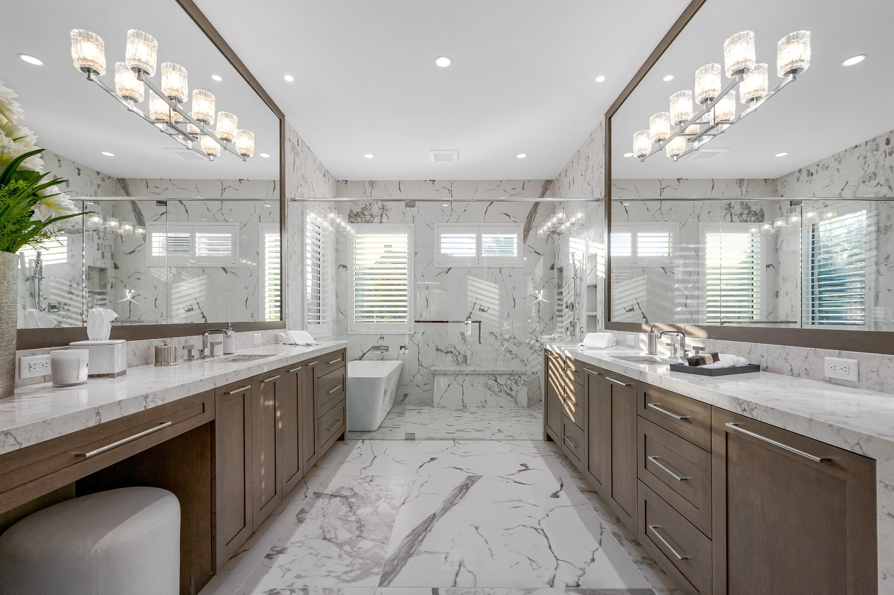 Large marble bath with generous mirrors and tailored cabinetry.