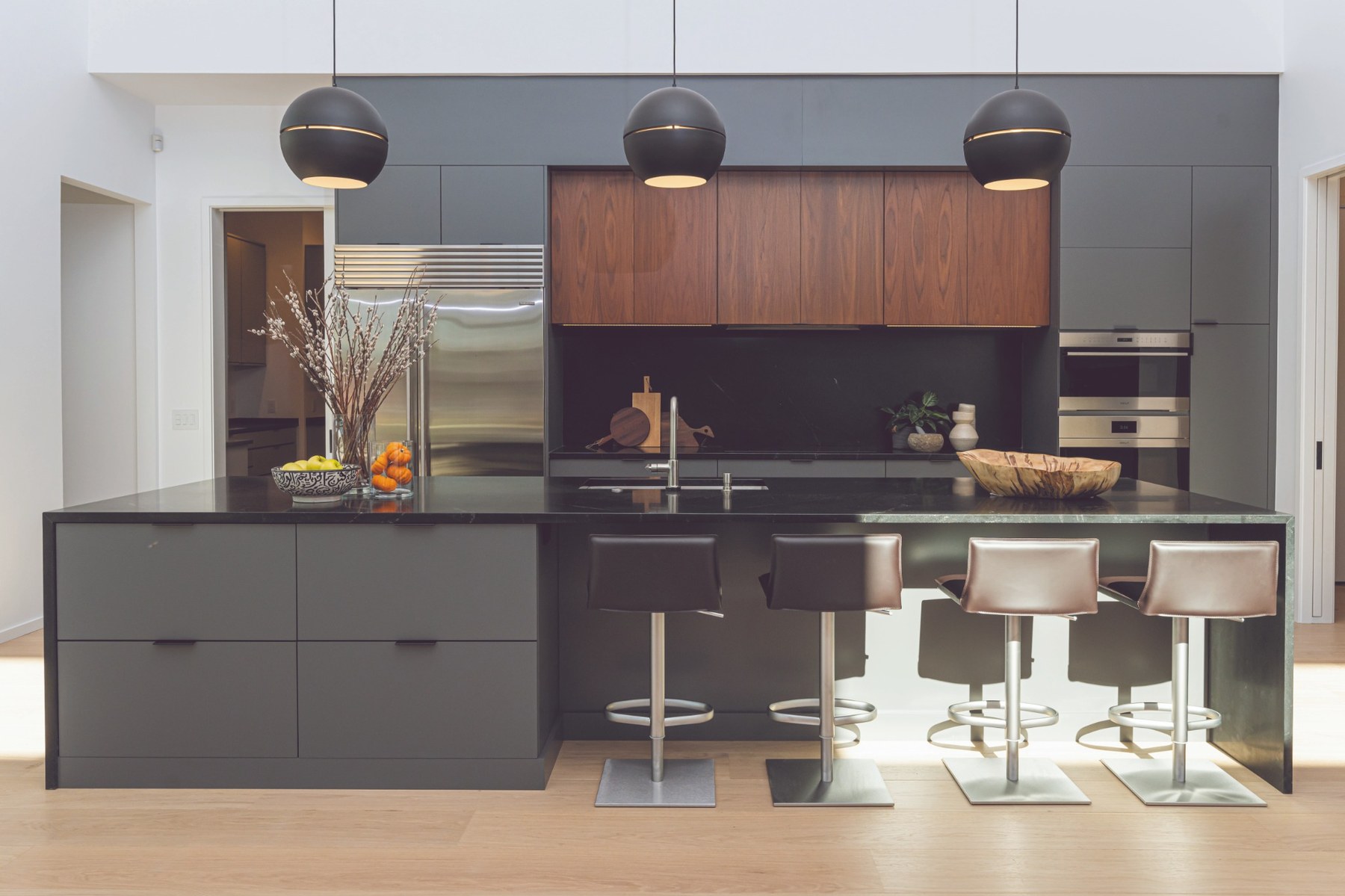 Modern kitchen with warm wood, dark cabinetry, and a grounded contemporary feel.